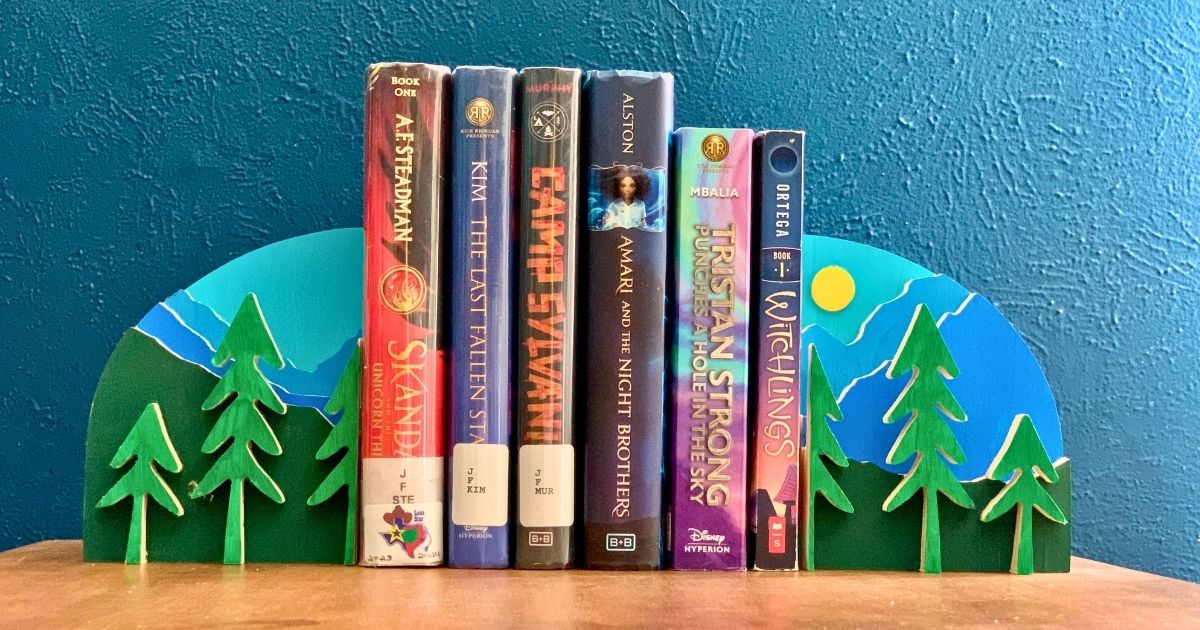 A row of books including Skandar and the Unicorn, Tristan Strong Punches a Hole in the Sky, Camp Sylvania, Amari and the Night Brothers, Witchlings, and The Last Fallen Star.