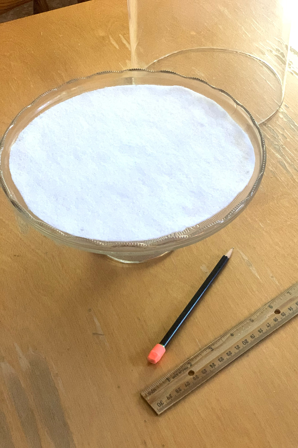 A circle a white felt on top of a glass cake stand.