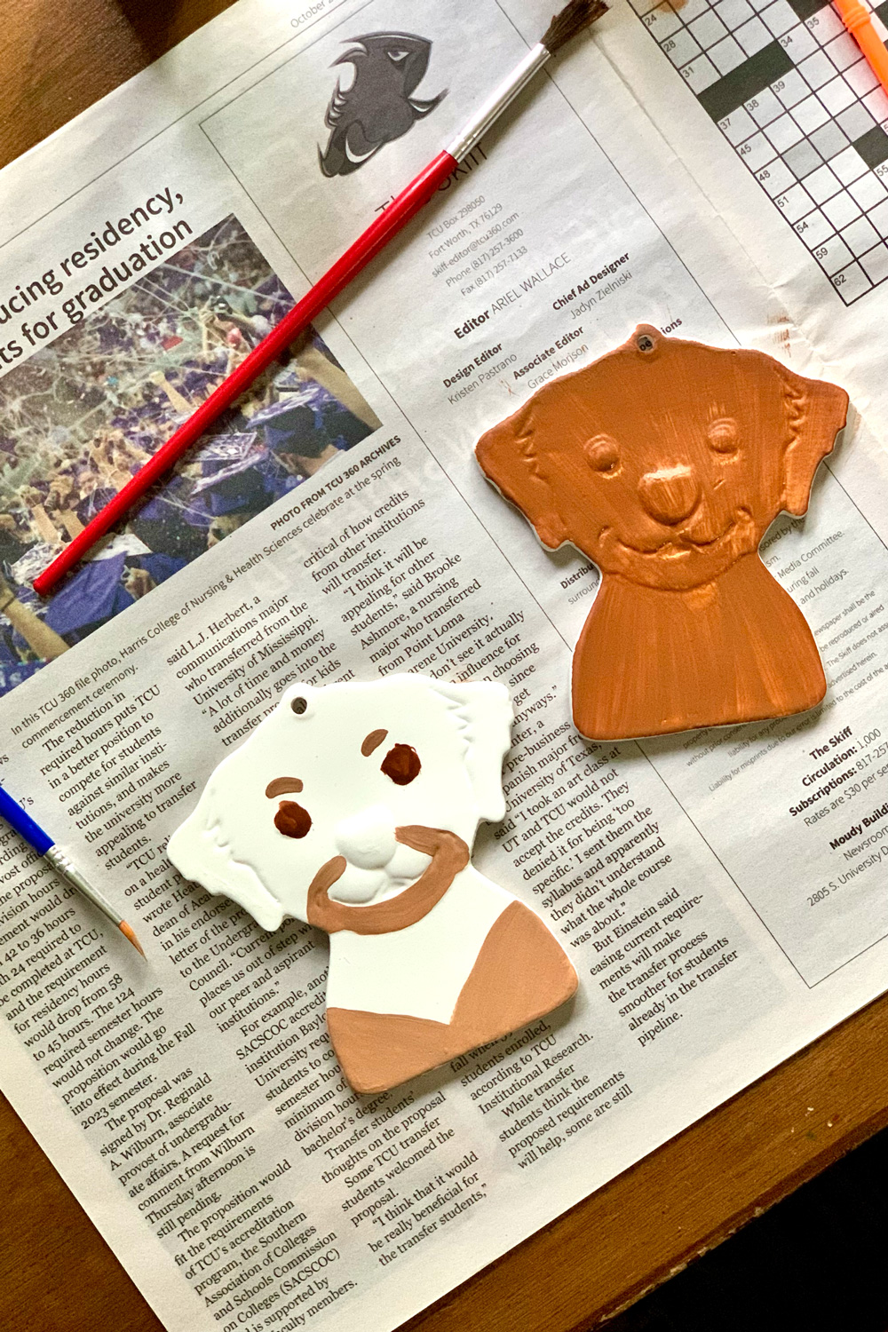 Two dog ornaments, one painted completely brown and the other painted brown in accent areas.
