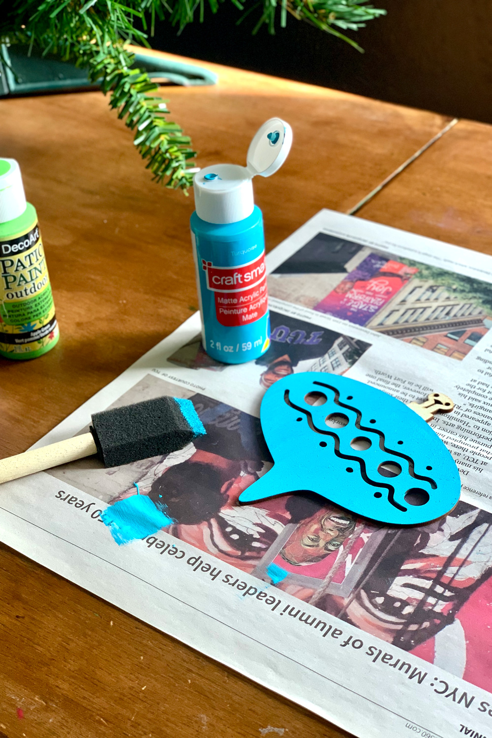 A wood ornament painted teal blue.