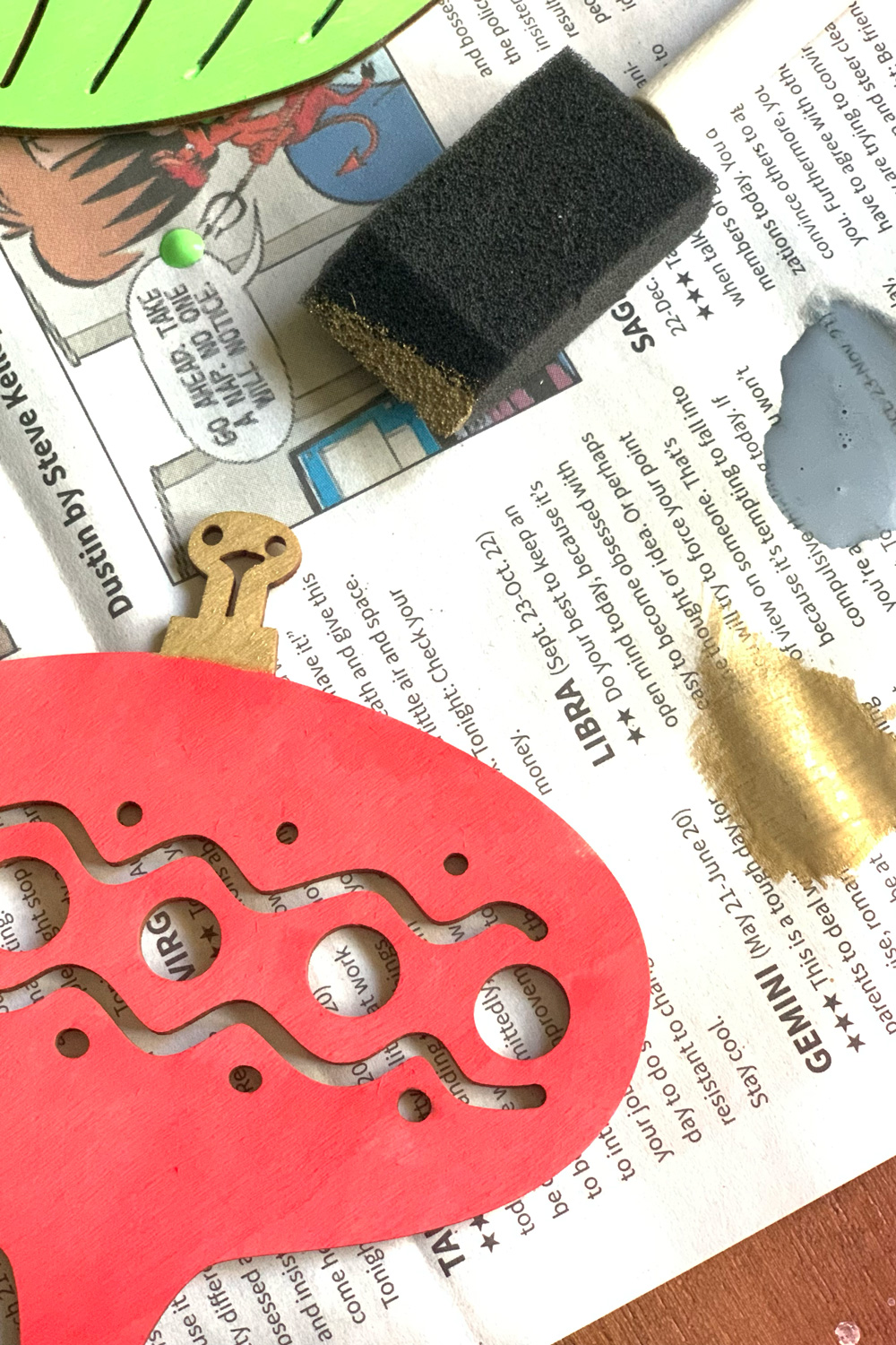 Painting the top clasp on the wooden ornaments gold.