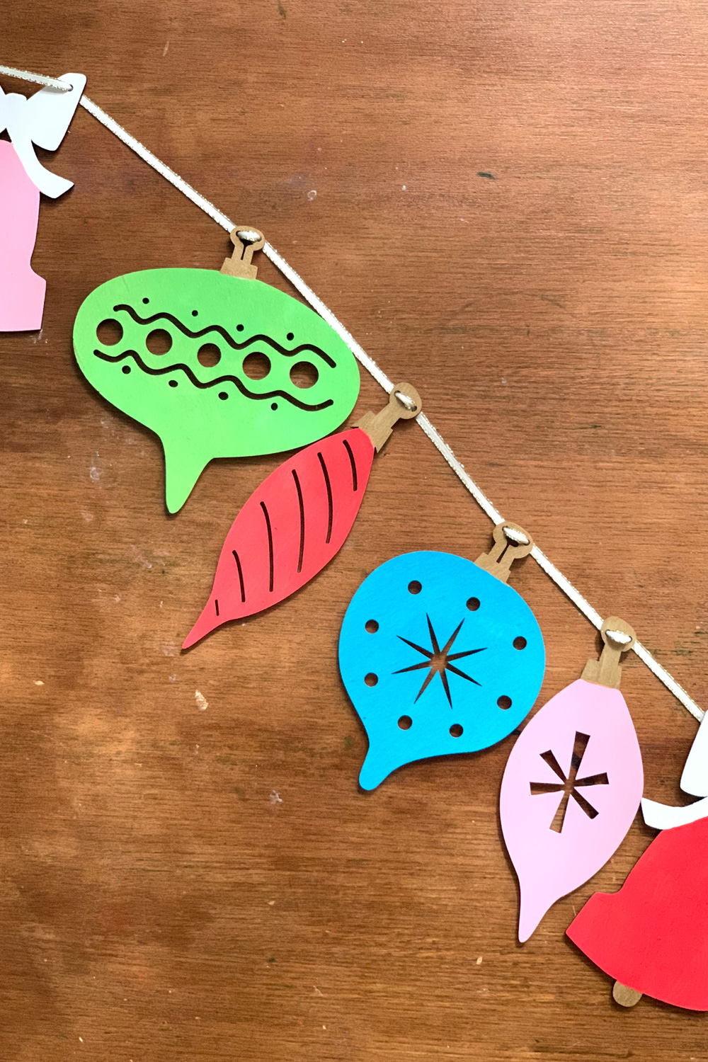 Retro wood ornament garland painted red, pink, lime green, and teal blue.