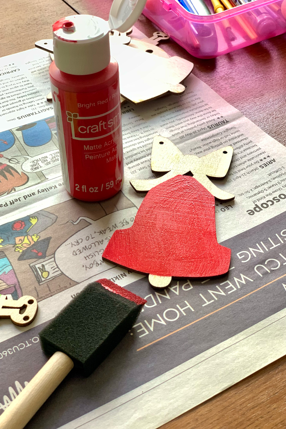 A wood bell ornament painted red.