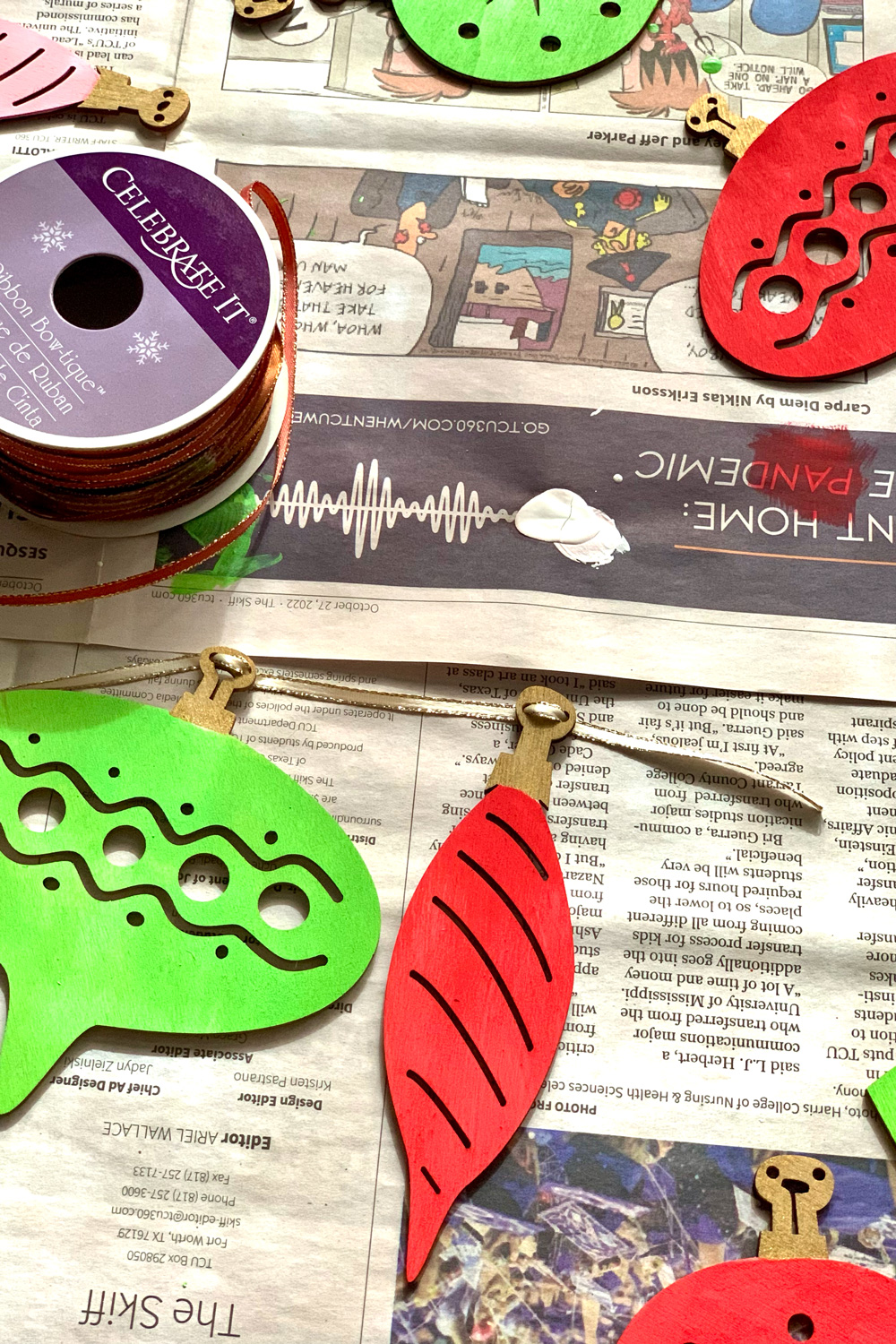 Threading ribbon through the top of each wooden ornament.