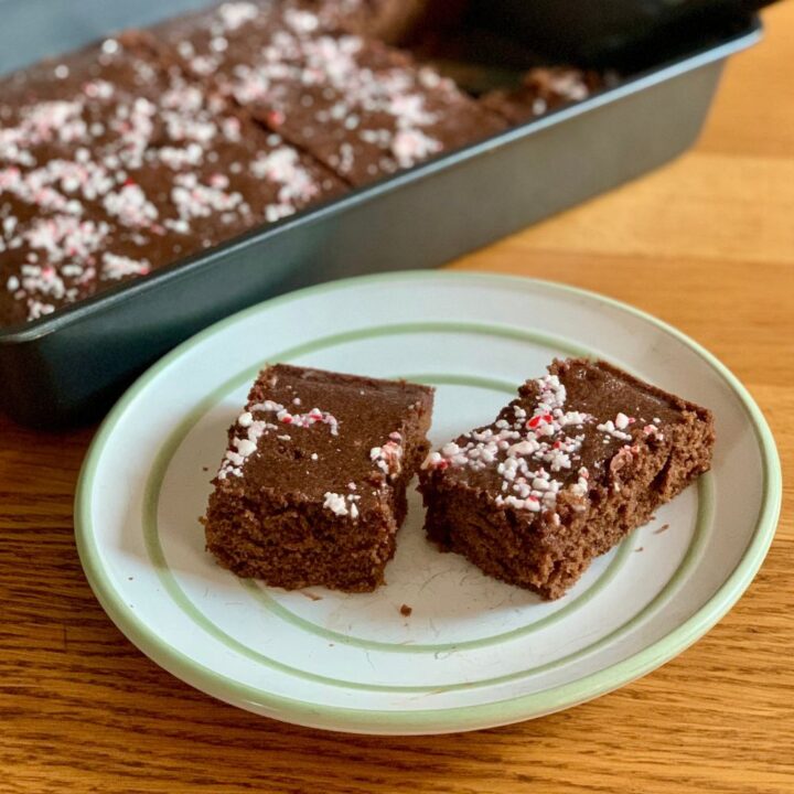 Two peppermint cake brownies with candy cane sprinkles on top.