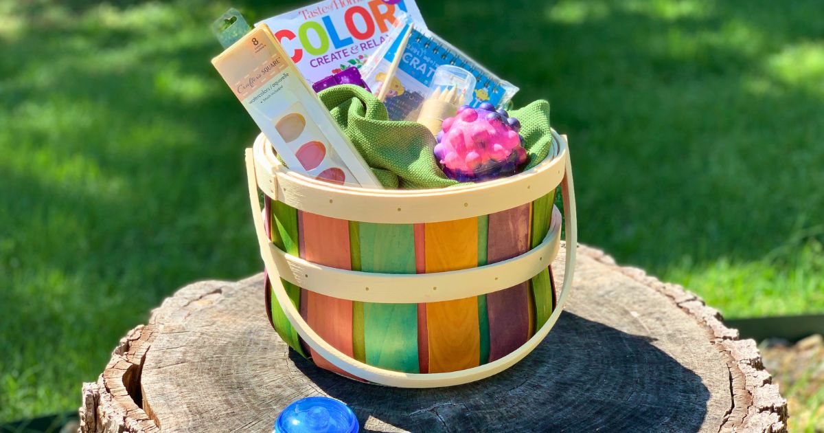 An Easter basket filled with a coloring book, scratch art kit, fidget toys, watercolor paints, and a yo-yo.