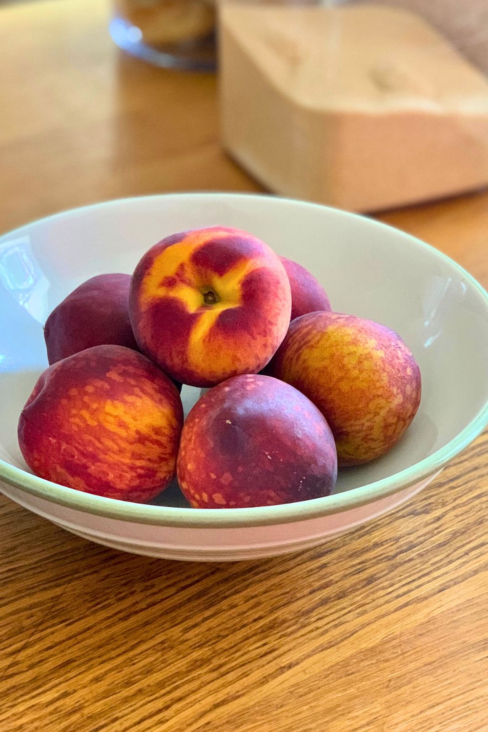 A bowl of whole, fresh peaches.