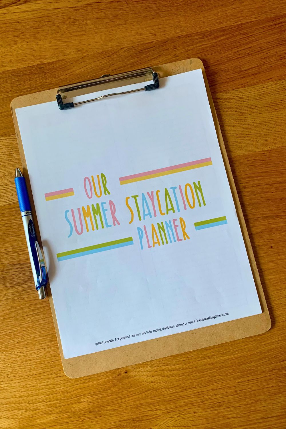 Printed planner cover that reads "our summer staycation planner" in bright pink, yellow, green, and blue letters.
