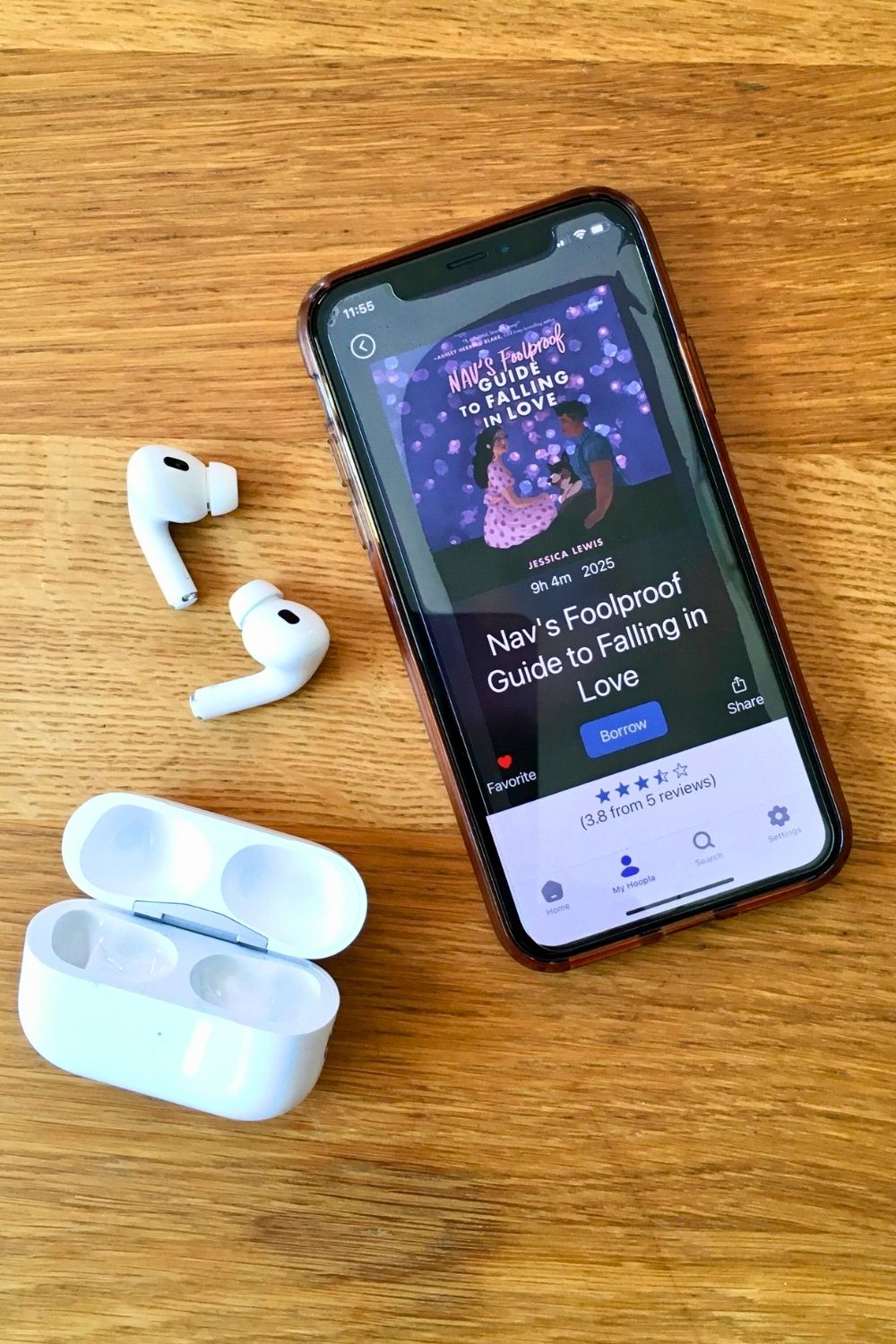 Airpods and iPhone with audiobook Nav's Foolproof Guide to Falling in Love by Jessica Lewis.