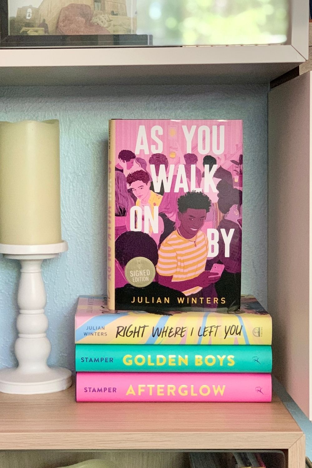 Stack of colorful books with As You Walk On By by Julian Winters on top.
