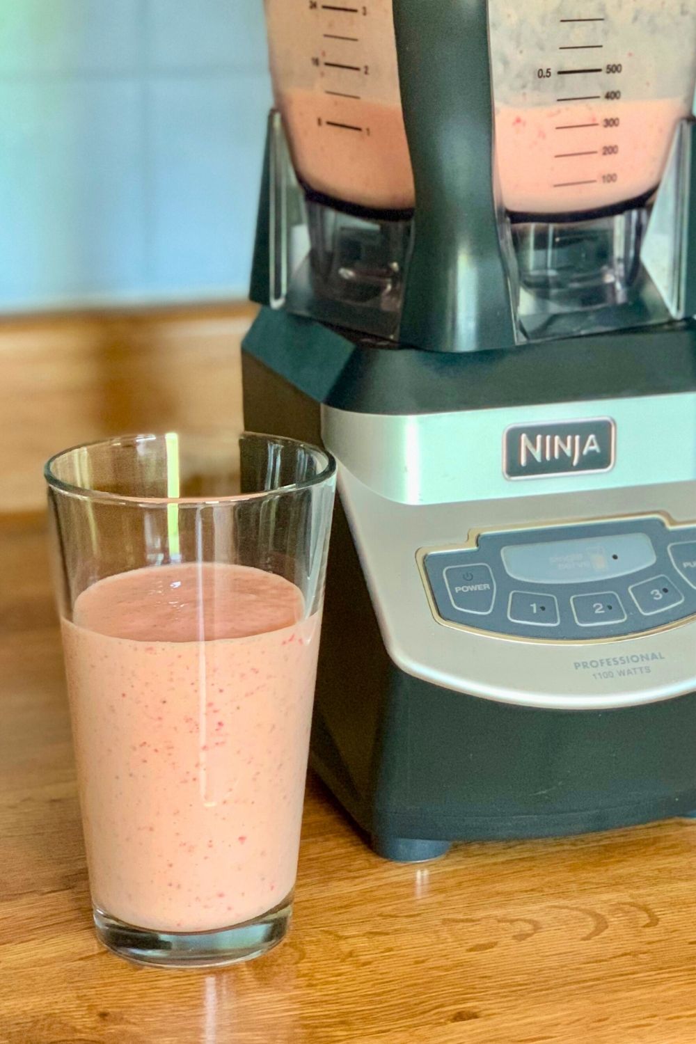 Glass of orange pink smoothie mixture.
