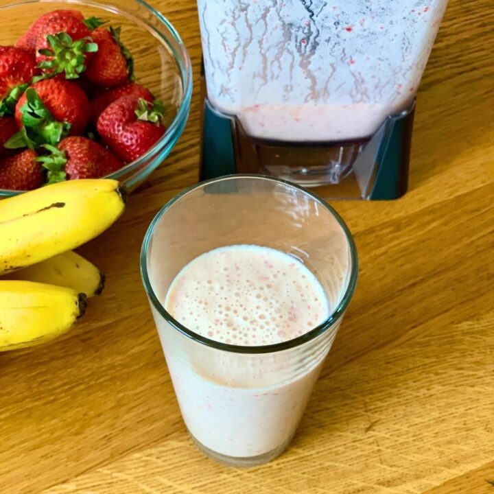 Pink-orange colored smoothie in a glass.