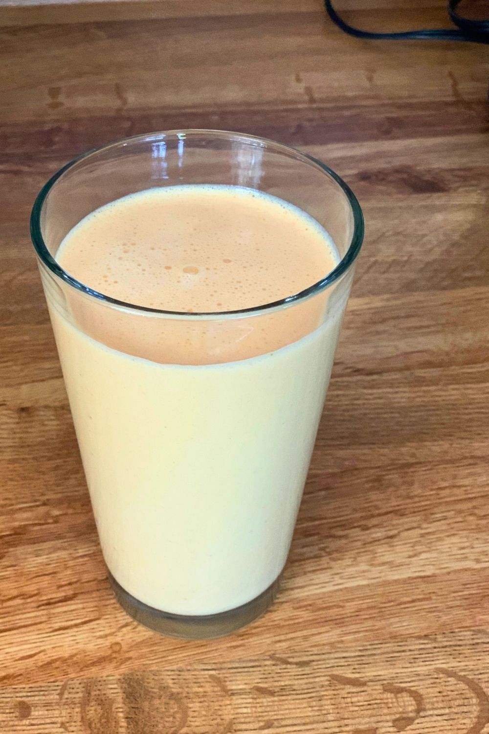 A tall glass full of smoothie.
