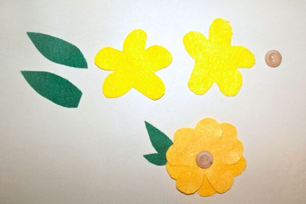 Felt flower petal and leaf shapes beside wood buttons.