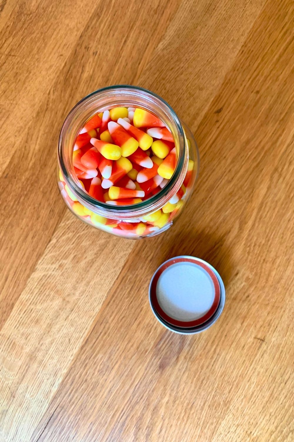 Filling a glass canning jar with candy corn.