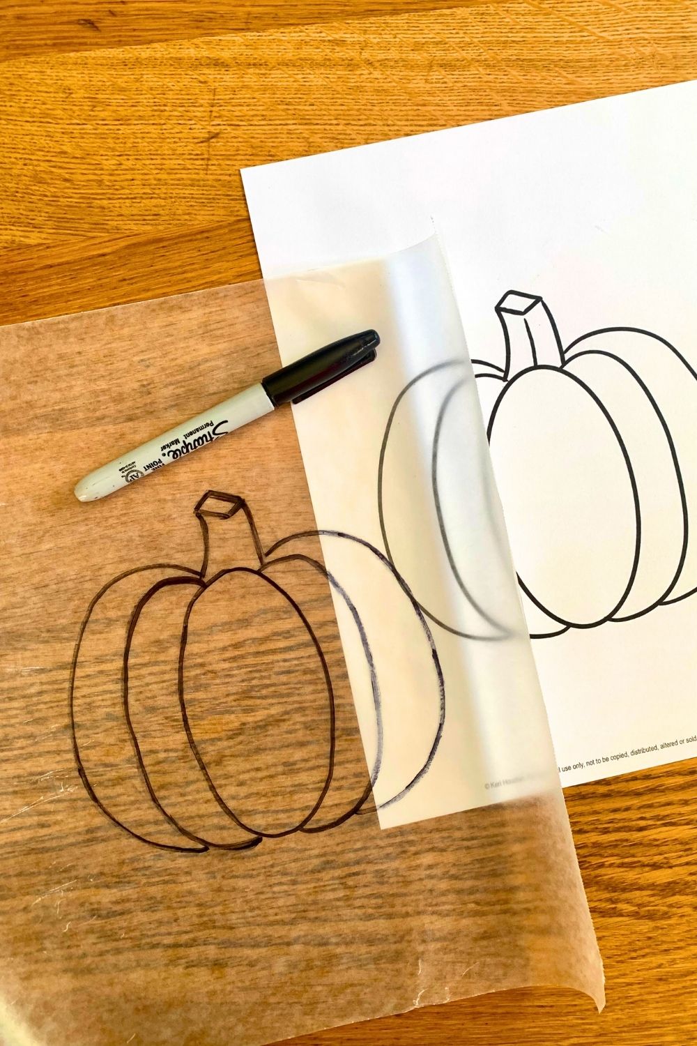 Tracing the pumpkin template onto wax paper with a permanent marker.