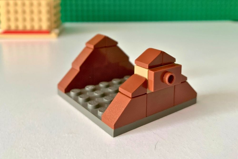 A baseplate with brown slopes stacked to make a triangle on either end.