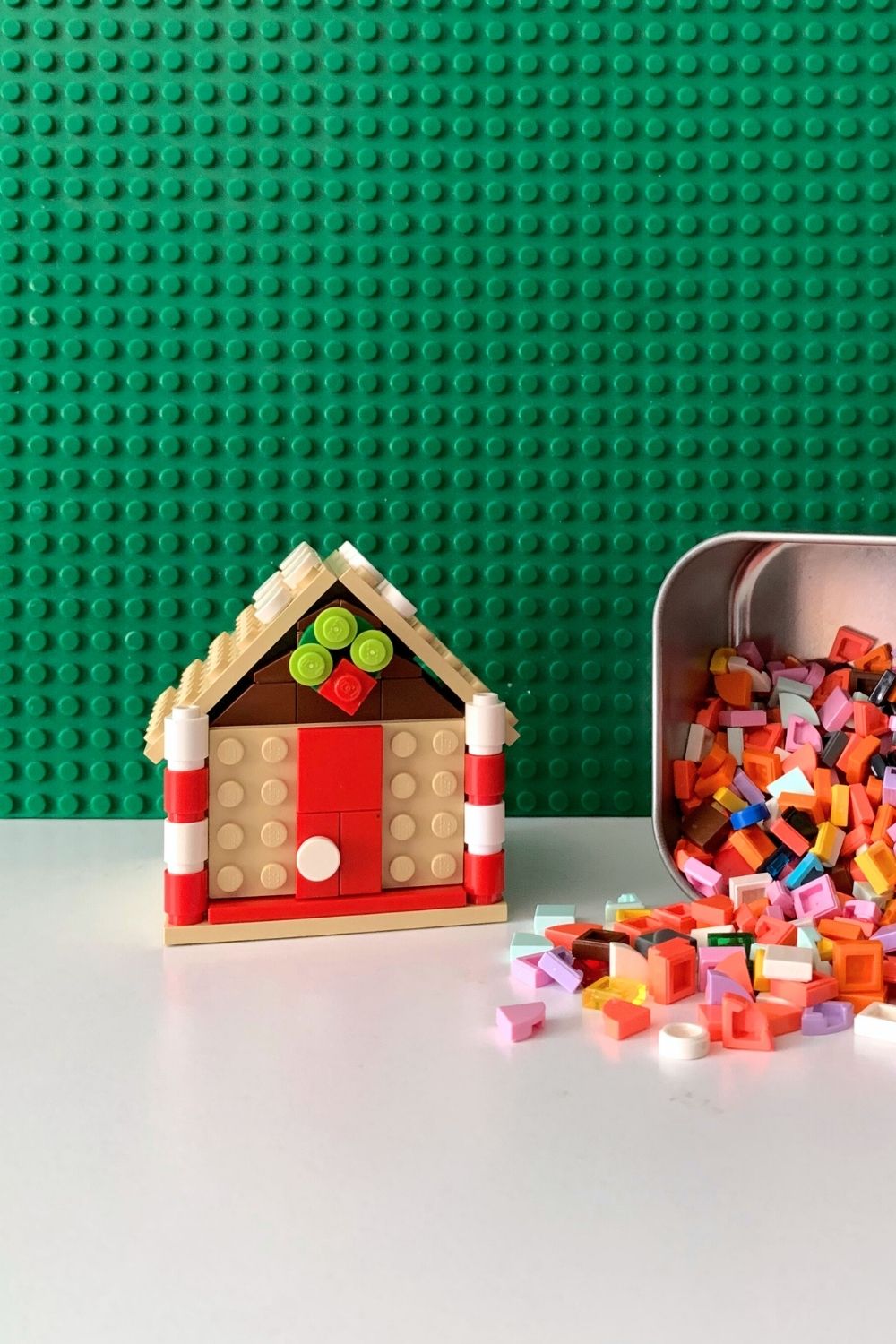 Small LEGO gingerbread house made from tan bricks decorated with tiny flat pieces.