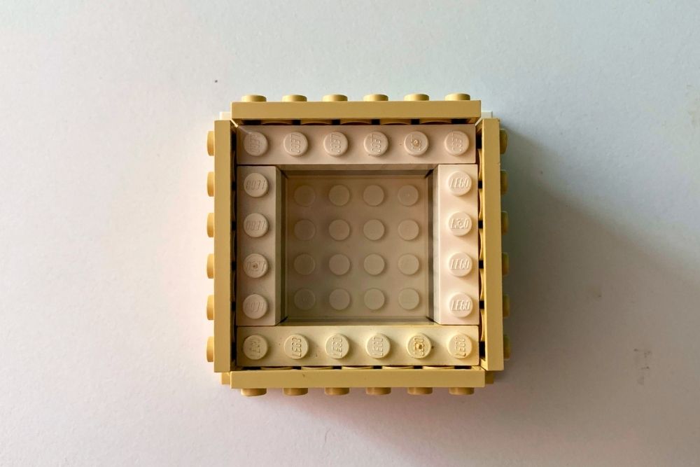Overhead view of a square house made from tan bricks 6-by-6 studs.