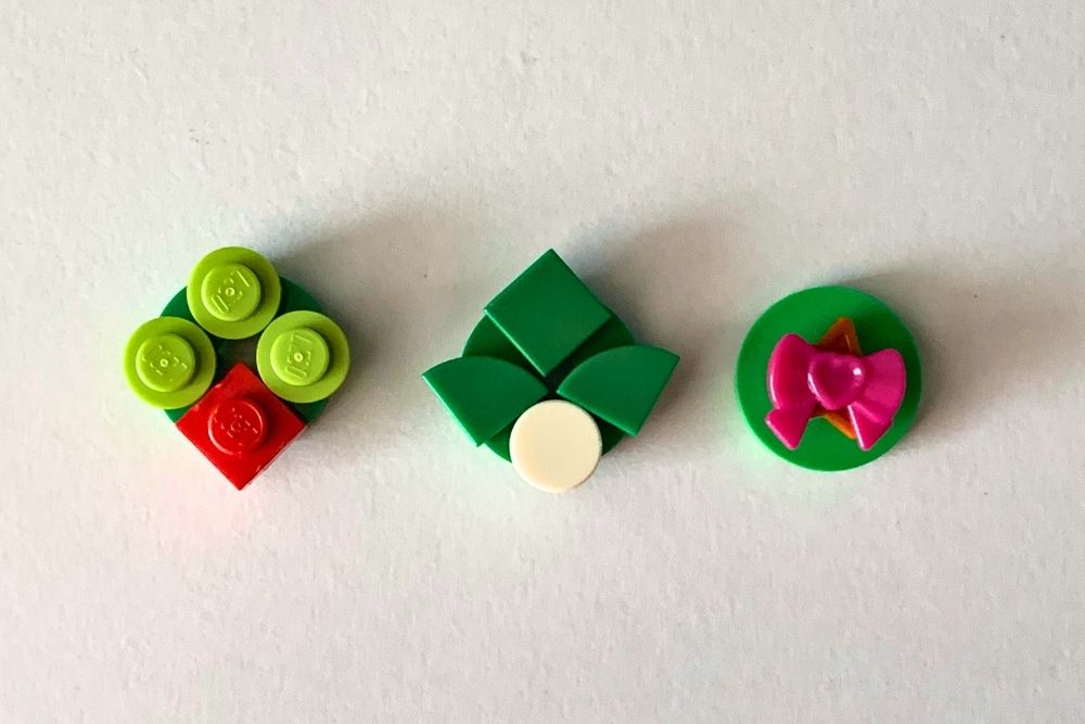 Flat green circles decorated with 1x1 bits in red, white, and green to create a wreath, mistletoe, and a bow.