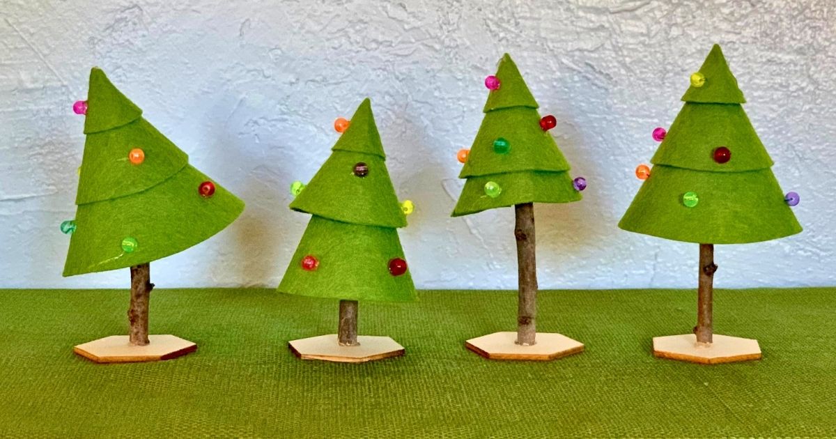 Christmas tree craft made from felt folded into cones, natural sticks, and decorated with beads.