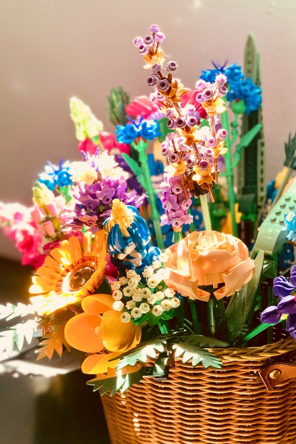 A bouquet of LEGO botanical flowers in a wicker basket.