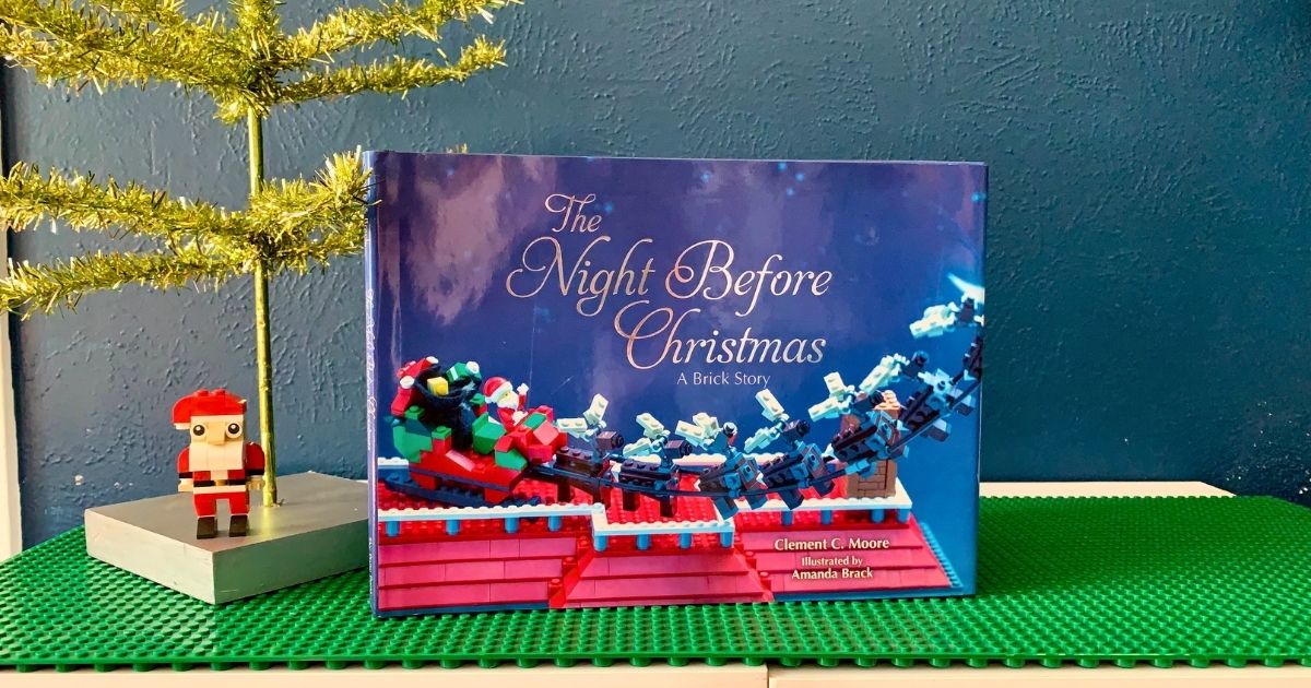 The Night Before Christmas: A Brick Story sitting beside a mini tree and a LEGO brick Santa Claus.