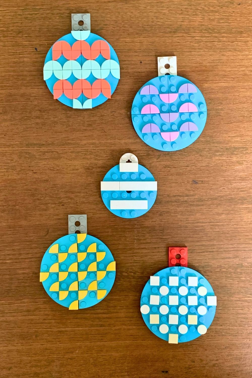 A mix of 5 LEGO ornaments made from blue circles decorated with colorful dots in patterns.