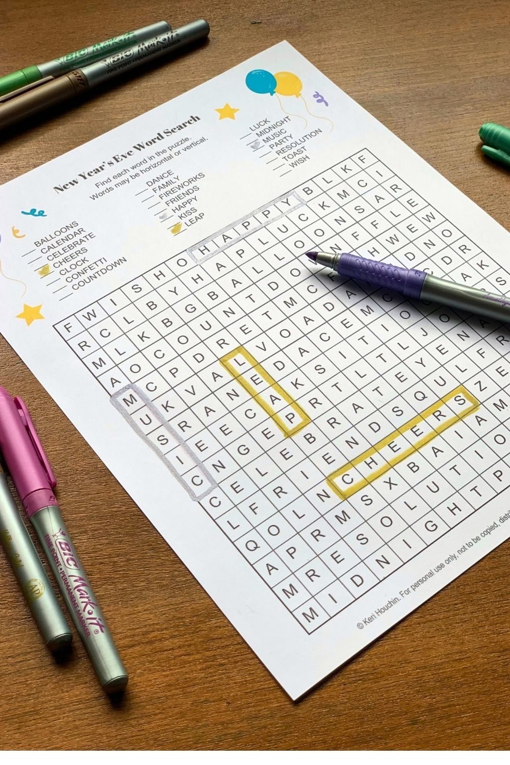 A metallic marker outlining boxes around the words music, leap, happy, and cheers on a grid.