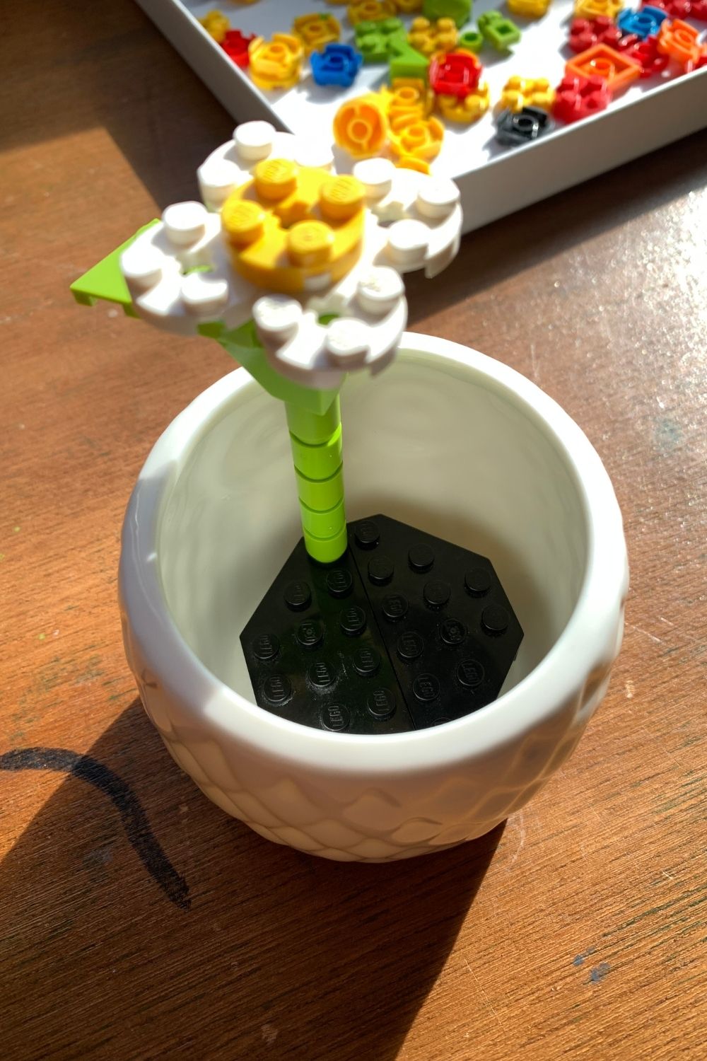 A single LEGO daisy in a flower pot.