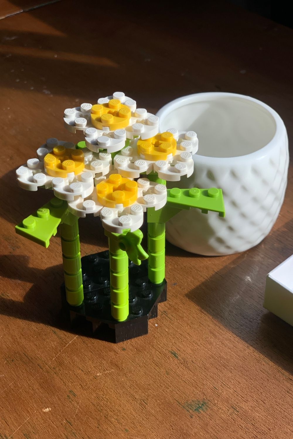 4 LEGO daisies attached to a base.