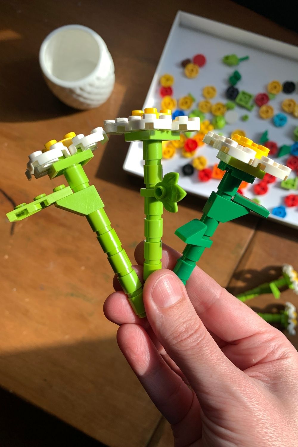 A trio of LEGO flowers with different shapes attached to the stems to resemble leaves and thorns.