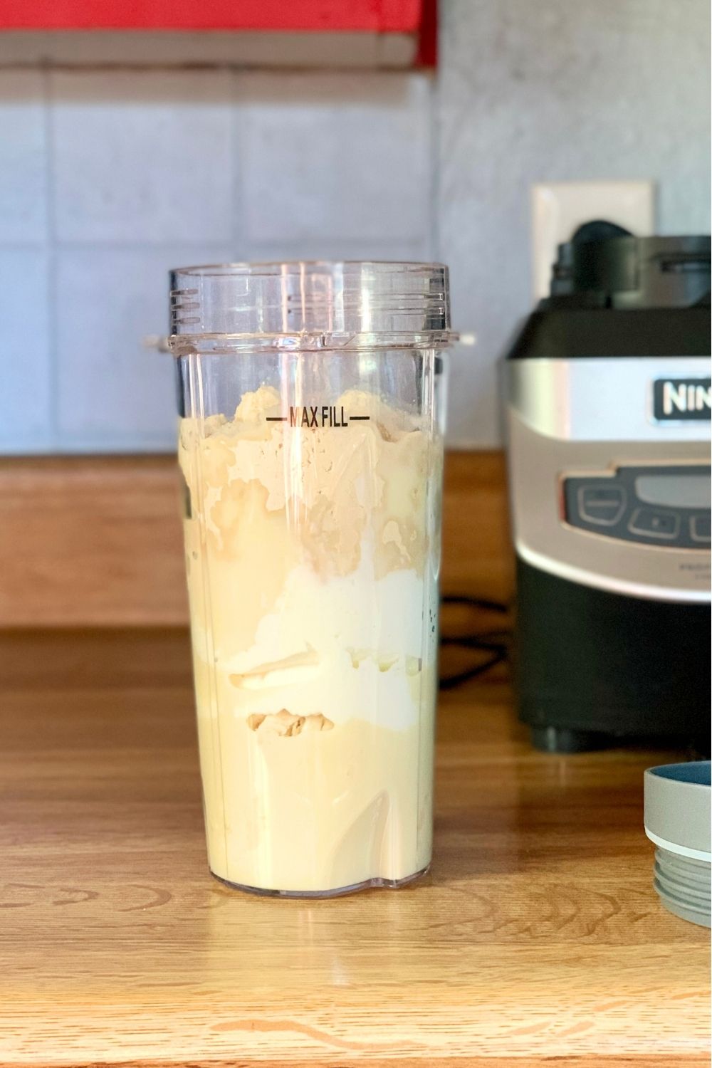 A smoothie cup filled with banana, yogurt, mango, and milk.