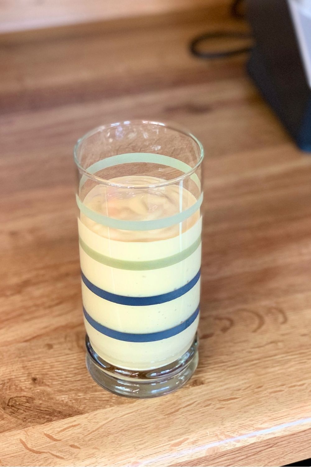 A creamy yellow mango smoothie in a glass.