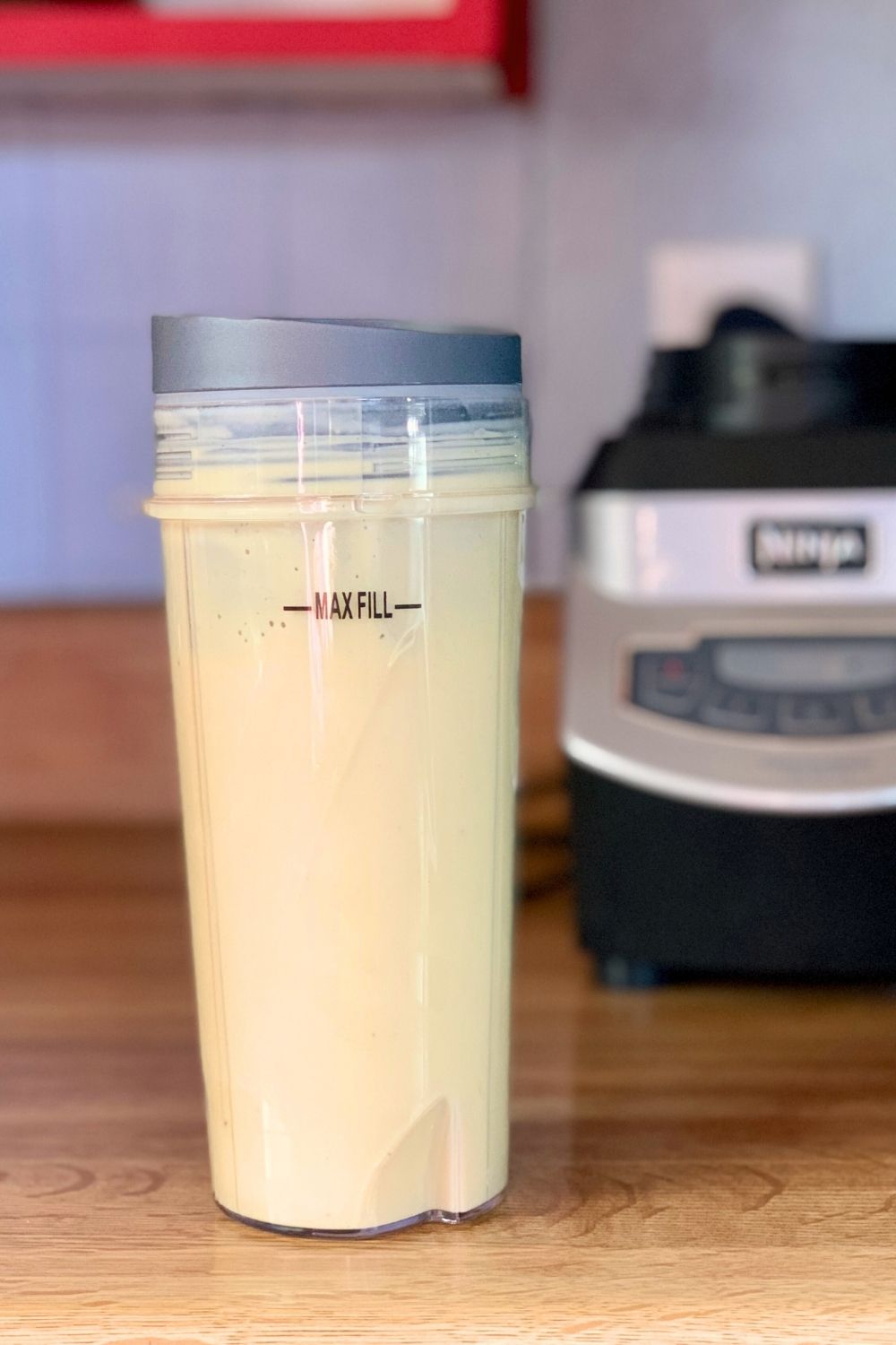 A creamy yellow mango smoothie in a blender cup.