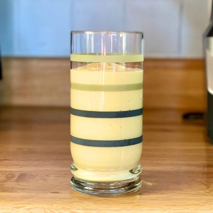 Mango smoothie in a striped glass.