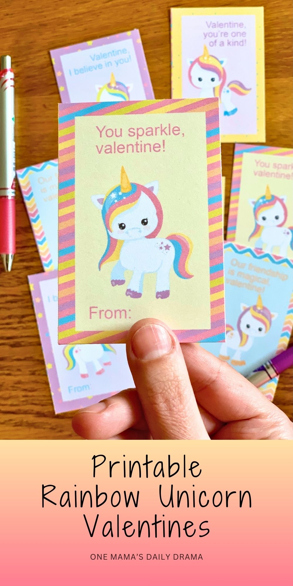 Holding one of the cards with a pink, blue, and yellow unicorn that reads "you sparkle, valentine."