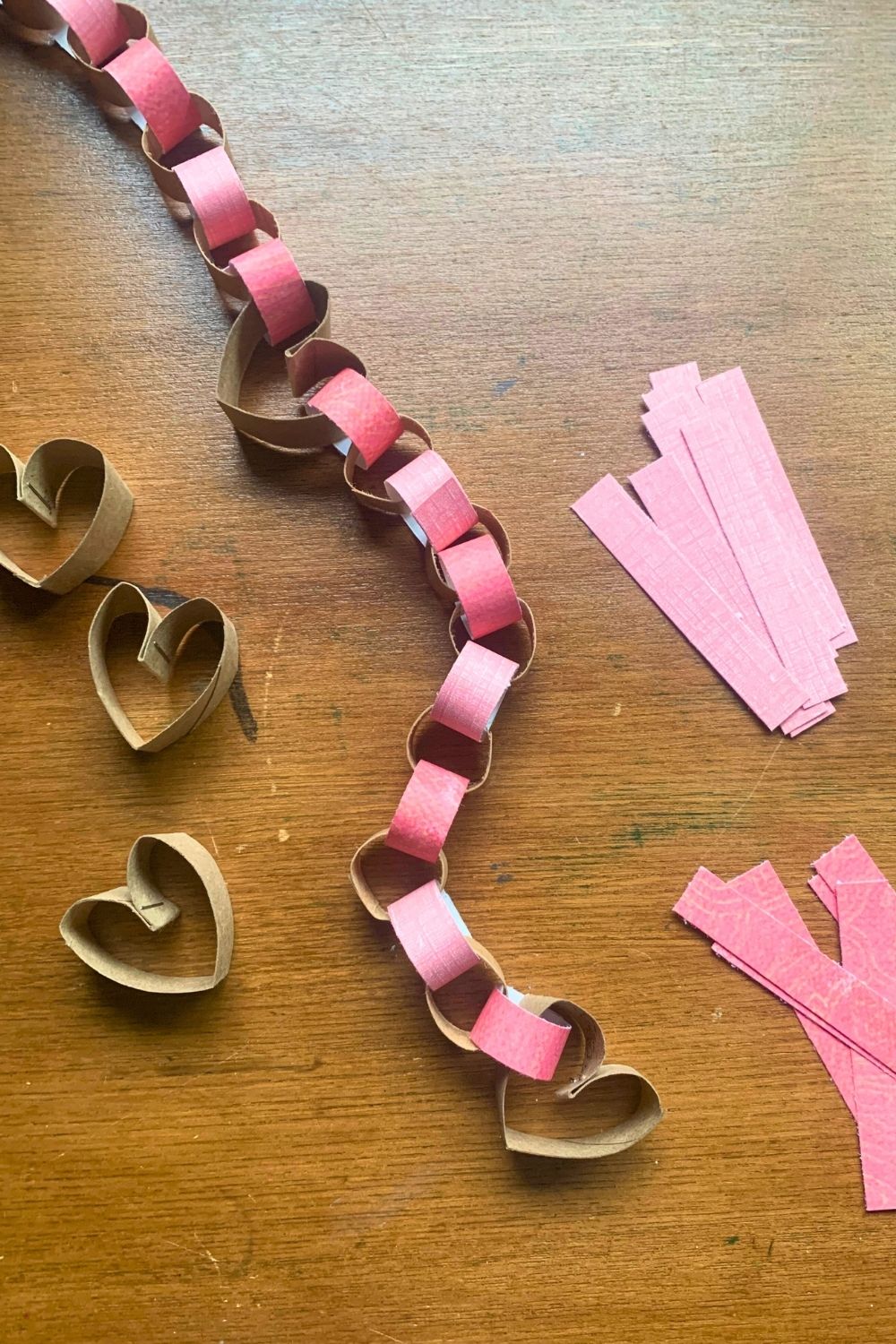 Valentine's Day garland made from paper tube hearts and pink paper chains.