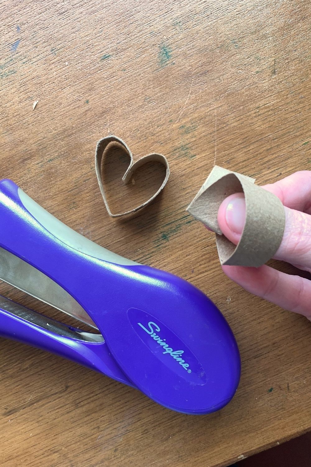 Folding a paper ring into a heart shape.