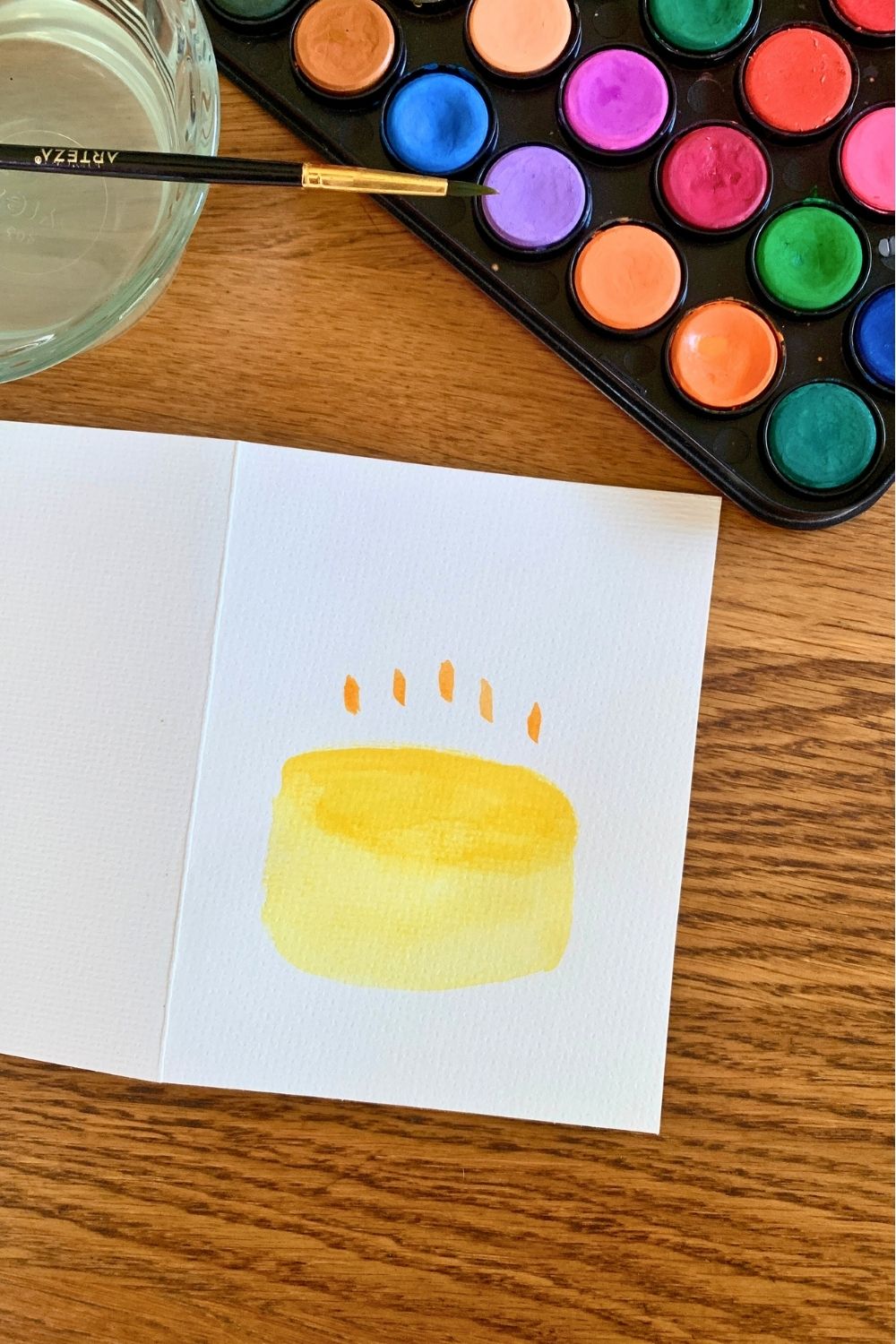 A yellow watercolor cylinder with five orange lines above it.