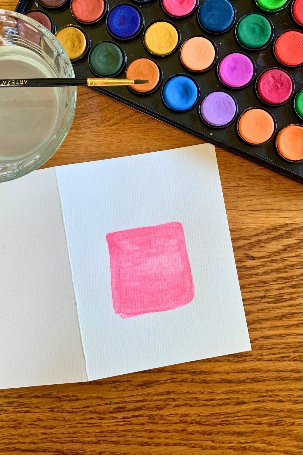 A red watercolor square on white paper.