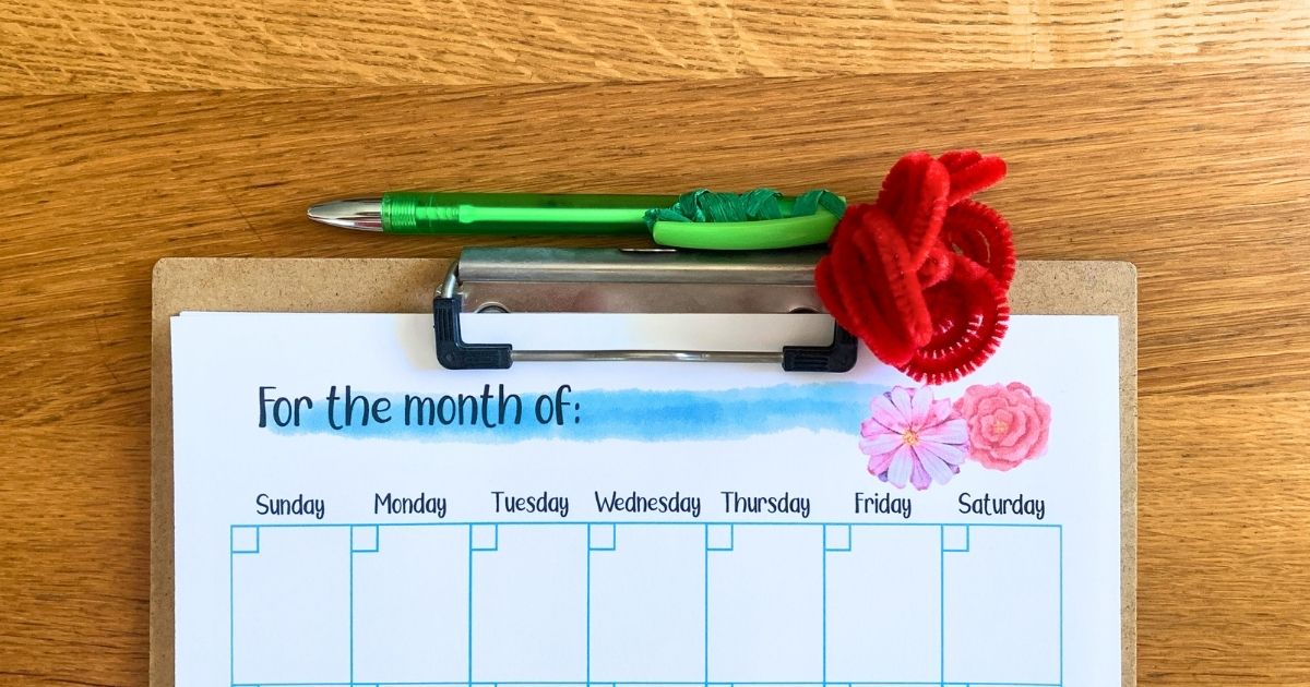 A pipe cleaner rose tied to the top of a green pen.