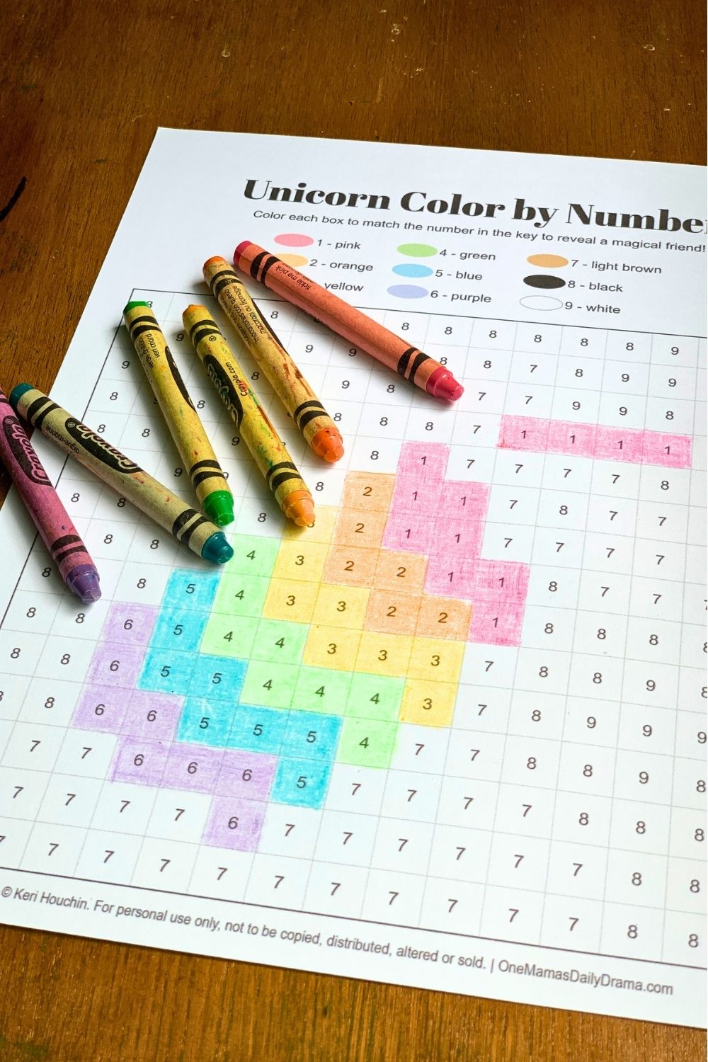 Crayons scattered over a coloring sheet with pink, yellow, green, blue, and purple colored boxes.