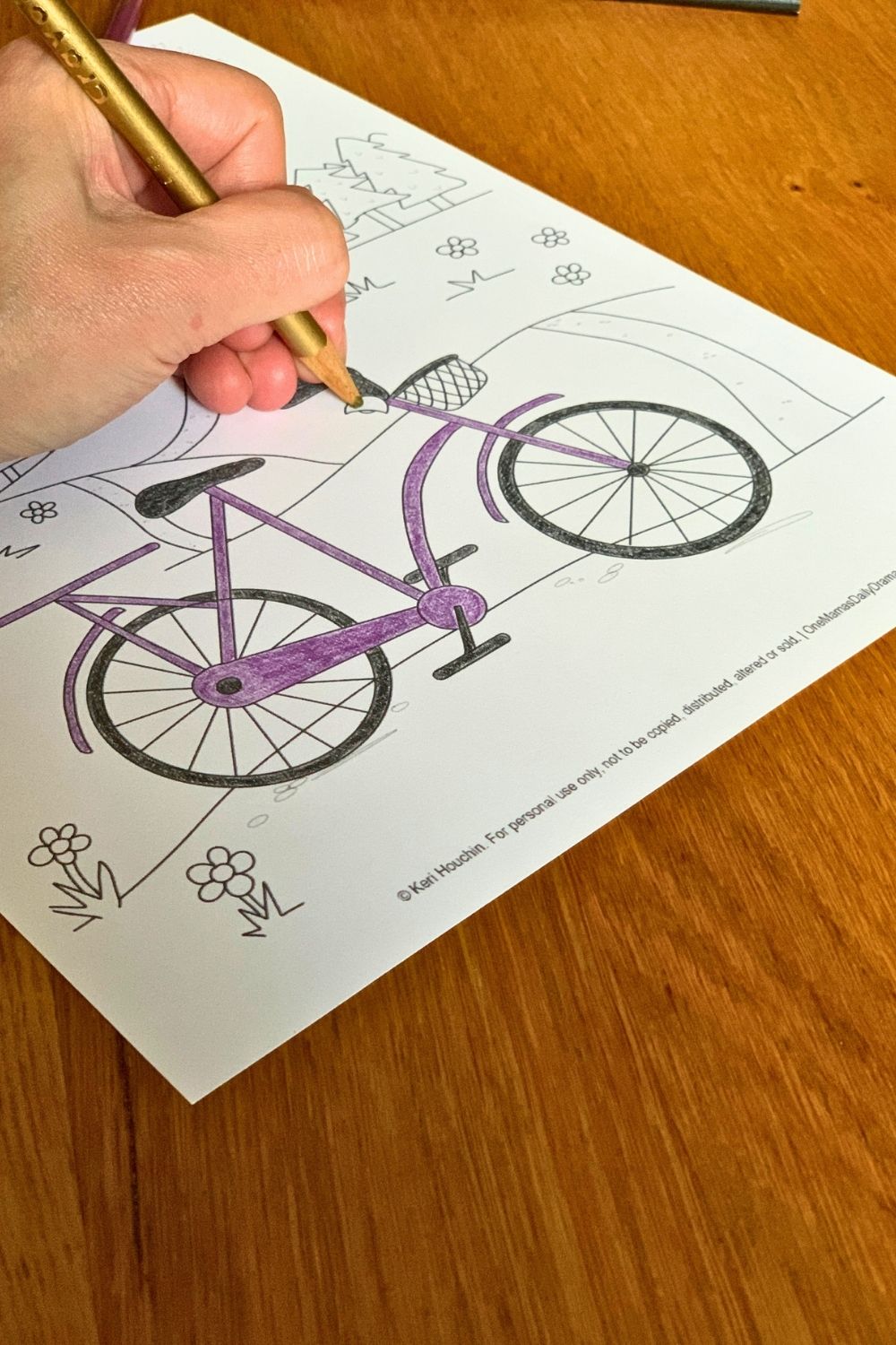 Coloring a picture of a bicycle purple with black accents and a gold bell.