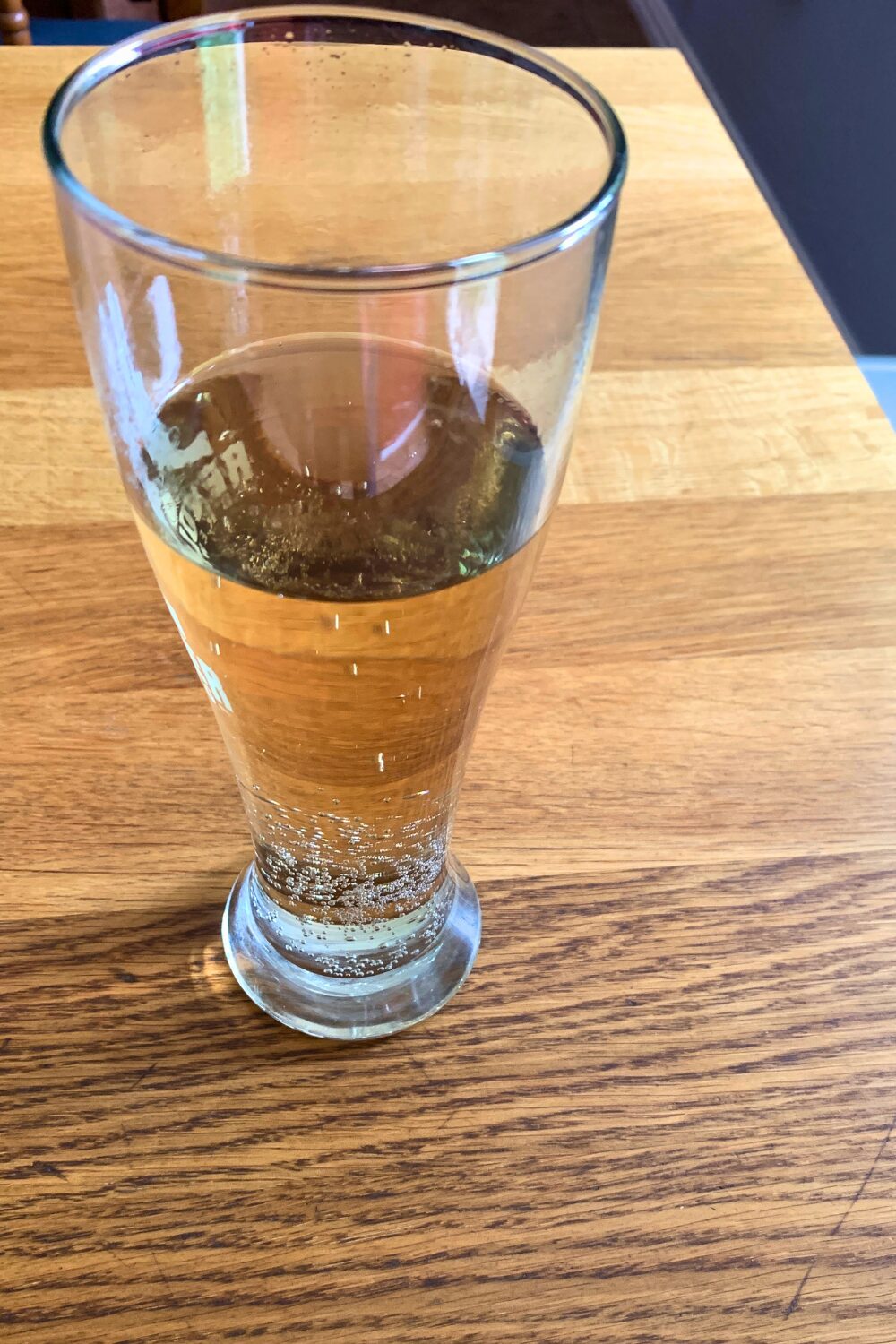 A glass half filled with ginger ale.