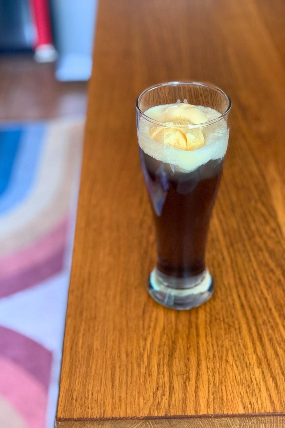 A glass of galaxy drink made with soda, purple syrup, and vanilla ice cream.