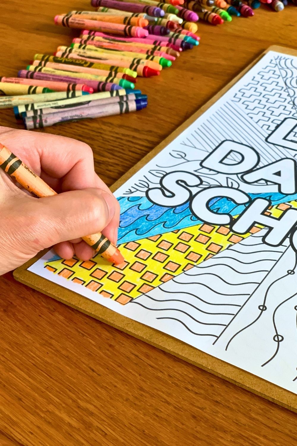Coloring a picture with orange crayon.