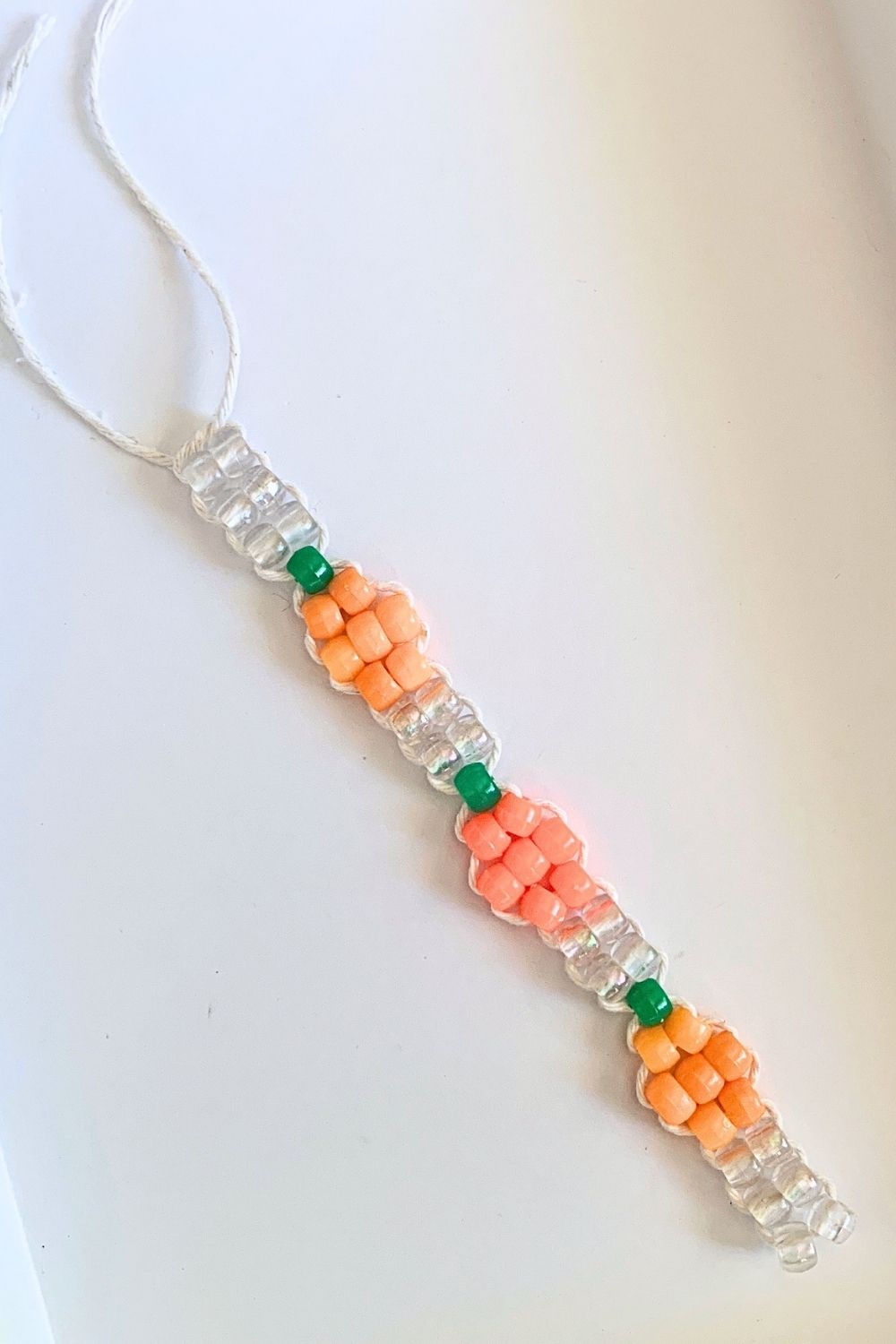 A finished pumpkin bracelet with 3 pumpkins separated by clear bead blocks.