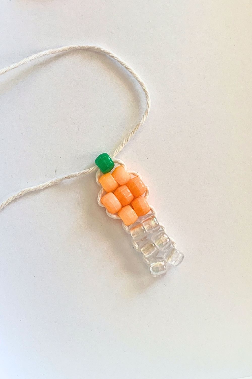 Adding a green bead after the orange ones to resemble a pumpkin with a stem.