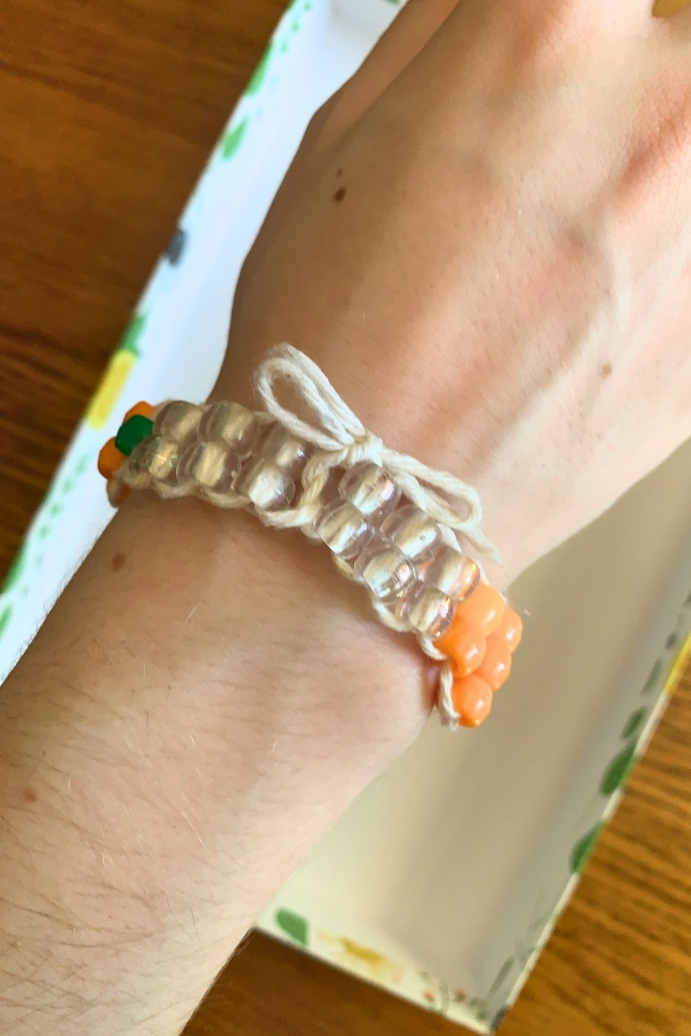 A bracelet tied closed in a bow around a person's wrist.
